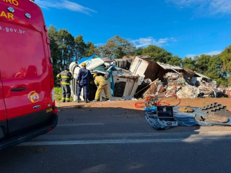 Carreta carregada com sucata tomba na ERS-135 e motorista fica preso às ferragens em Erechim